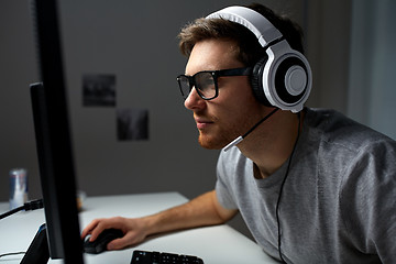 Image showing man in headset playing computer video game at home