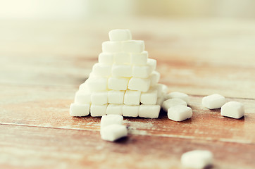 Image showing close up of white sugar pyramid on wooden table