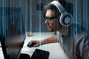 Image showing man in headset playing computer video game at home