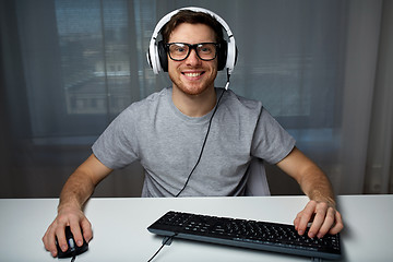 Image showing man in headset playing computer video game at home