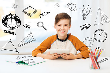 Image showing smiling boy with tablet pc and notebook at home