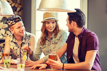 Image showing happy friends drinking beer and cocktails at bar