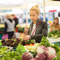 Image showing Woman buying vegetable at local food market. 