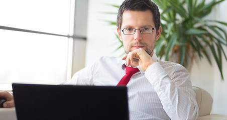 Image showing Portrait of businessman working on laptop computer