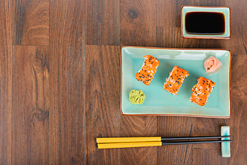 Image showing Sushi rolls on the wooden table. Overhead view