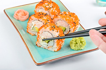 Image showing Sushi roll with black chopsticks 