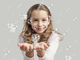 Image showing Girl playing with soap bubbles