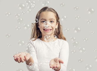 Image showing Girl playing with soap bubbles