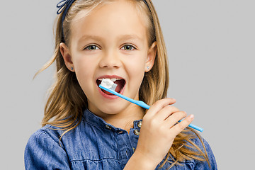 Image showing Little girl brushing teeth