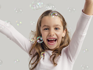 Image showing Girl playing with soap bubbles