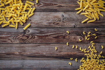 Image showing Mixed dried pasta selection on wooden background.