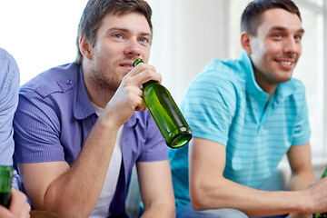 Image showing happy male friends drinking beer at home