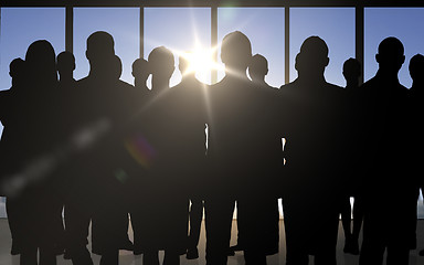 Image showing business people silhouettes over office background