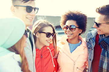 Image showing happy teenage friends in shades talking on street