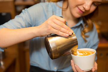 Image showing close up of woman making coffee at shop or cafe