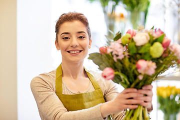 Image showing smiling florist woman making bunch at flower shop