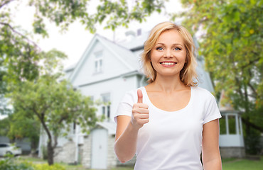 Image showing smiling woman in white t-shirt showing thumbs up