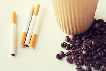 Image showing close up of cigarettes, coffee cup and beans