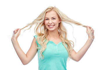 Image showing smiling young woman holding strands of her hair