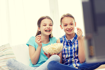 Image showing happy girls with popcorn watching tv at home