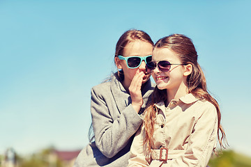 Image showing happy girl whispering secret to her friends ear