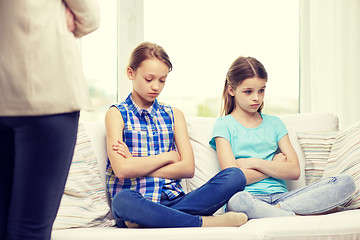 Image showing upset guilty little girls sitting on sofa at home