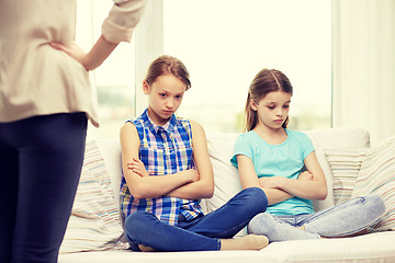 Image showing upset guilty little girls sitting on sofa at home