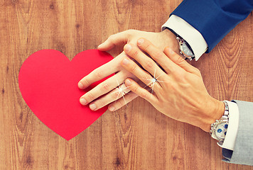 Image showing close up of male gay couple hands with red heart