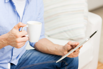 Image showing close up of man with tablet pc and tea cup at home