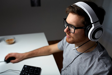 Image showing man in headset playing computer video game at home