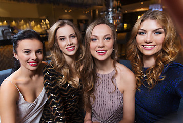 Image showing happy smiling women taking selfie at night club