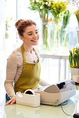 Image showing smiling florist woman at flower shop cashbox