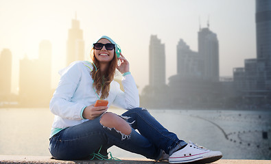 Image showing happy young woman with smartphone and headphones