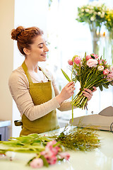 Image showing smiling florist woman making bunch at flower shop