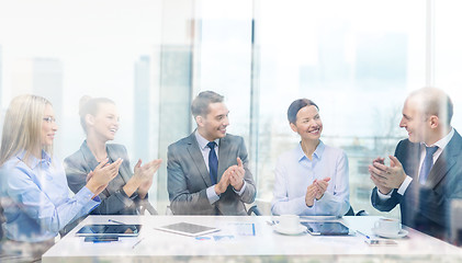 Image showing business team with laptop clapping hands