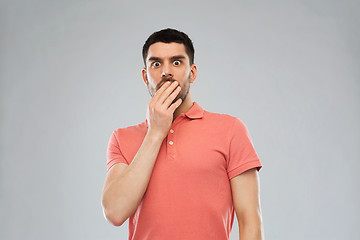 Image showing scared man in polo t-shirt over gray background