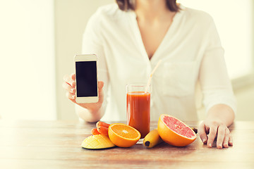 Image showing close up of woman hands with smartphone fruits