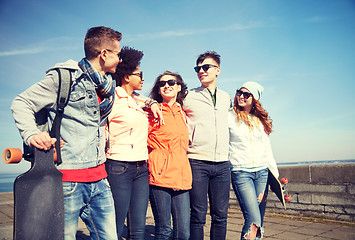 Image showing happy teenage friends with longboards on street