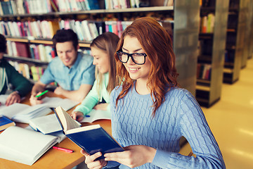 Image showing happy students reading books in library