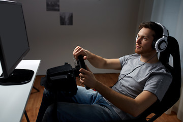 Image showing man playing car racing video game at home