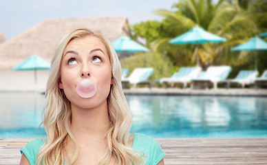 Image showing happy woman or teenage girl chewing gum on beach