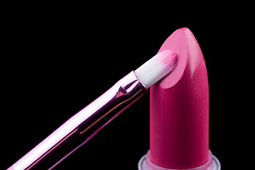 Image showing Tube of lipstick with a brush make-up on black 