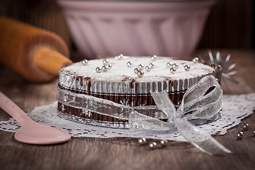 Image showing White and chocolate Christmas cake with baking utensils