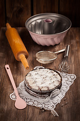 Image showing White and chocolate Christmas cake with baking utensils