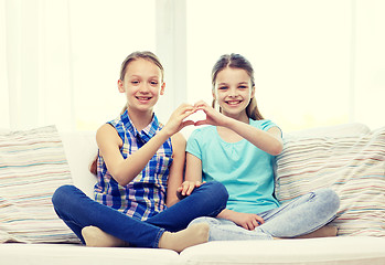 Image showing happy little girls showing heart shape hand sign