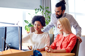 Image showing happy creative team with computer in office