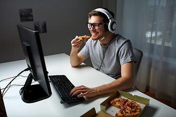 Image showing man in headset playing computer video game at home