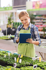 Image showing happy woman with tablet pc in greenhouse