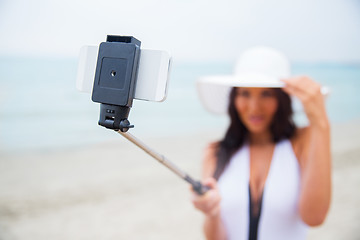 Image showing smiling young woman taking selfie with smartphone