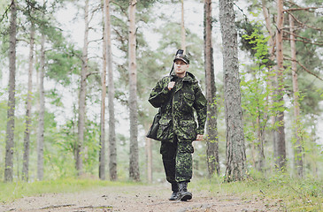 Image showing young soldier or hunter with gun in forest